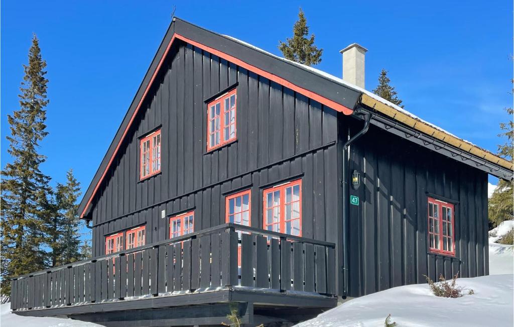 a black house with red windows in the snow at Beautiful Home In yer With Wifi And 3 Bedrooms in Øyer