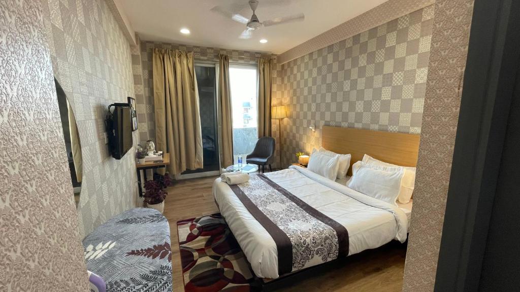 a hotel room with a bed and a television at Saltstayz Studio Apartment - Near Artemis & Medanta Hospital in Gurgaon