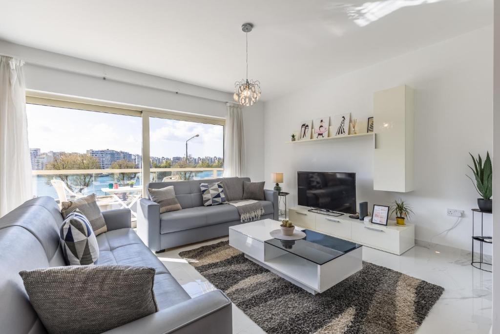 a living room with a couch and a tv at Stunning - SunnySide 3-Bedroom in Sliema