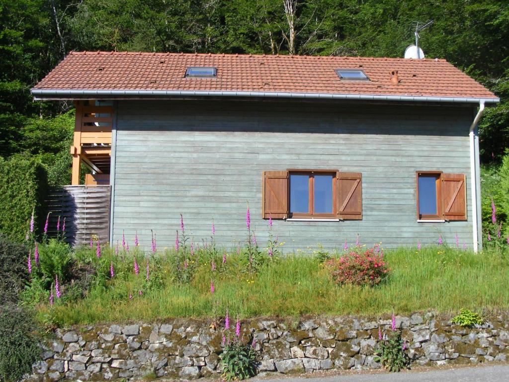 a small house with two windows and a stone wall at le chalet in Saint-Nabord