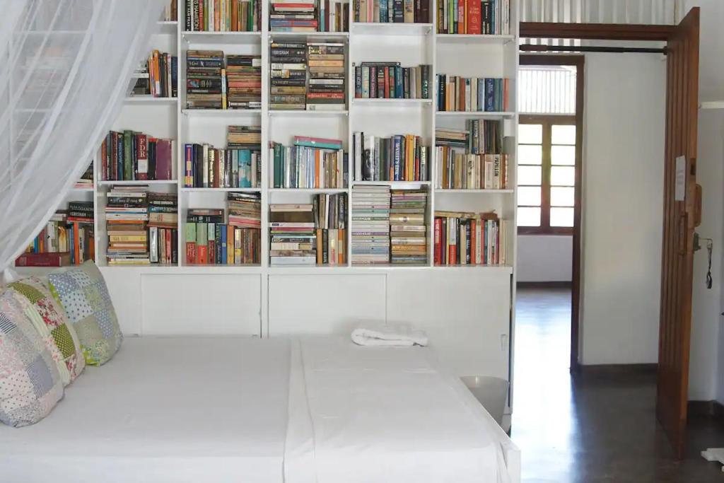 a room with a white book shelf filled with books at Colombo 07 Charming Home Stays in Colombo