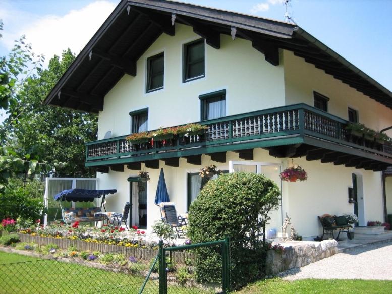 a large white house with a balcony and a yard at Ferienwohnung Trattler in Chieming