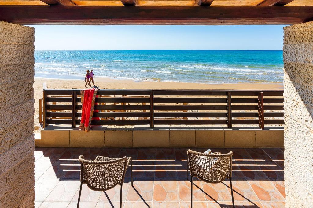 uma vista para a praia a partir de uma varanda com 2 cadeiras em Mare del Sud em Donnalucata