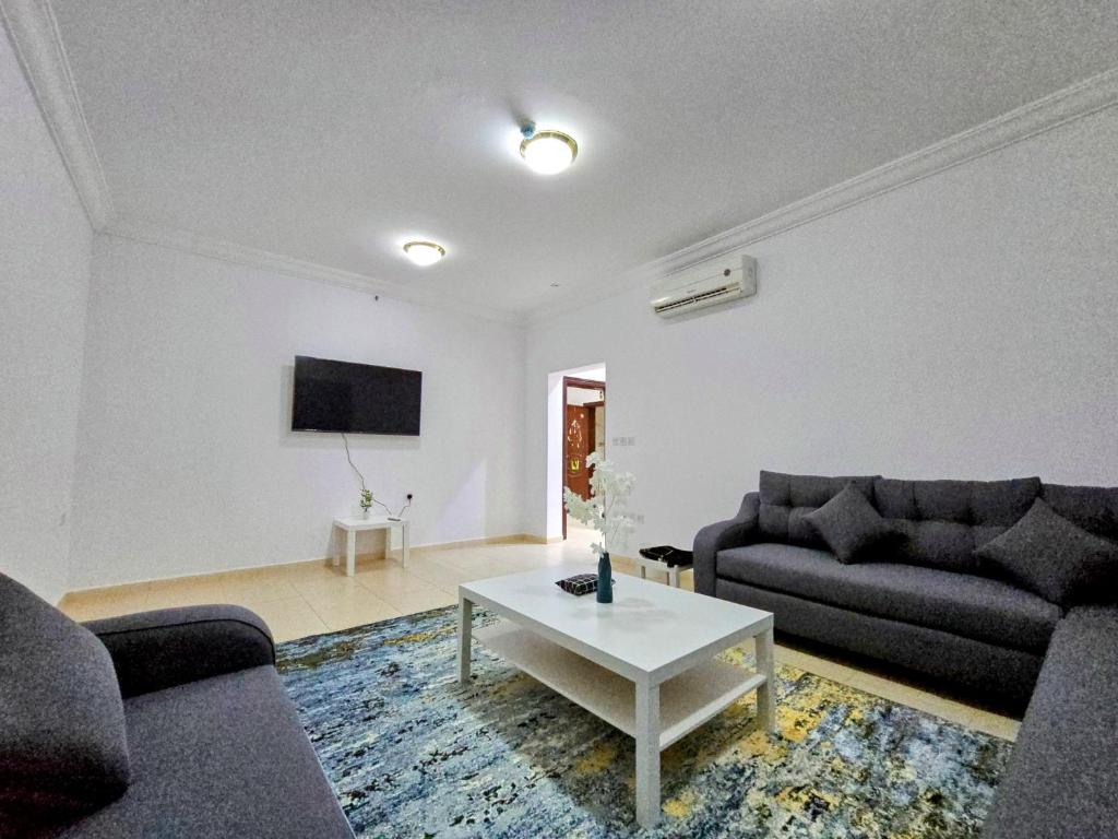 Spacious Apartment في مكة المكرمة: غرفة معيشة مع كنبتين وطاولة