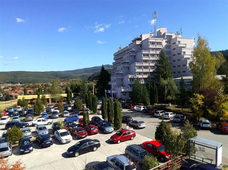 a parking lot with cars parked in front of a building at Hotel Montana - Covasna in Covasna