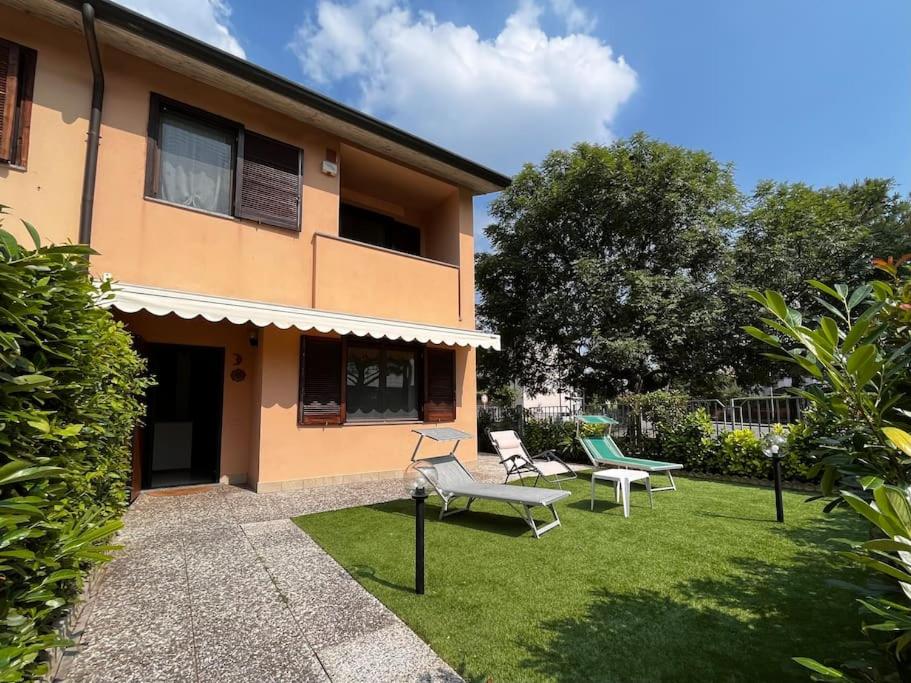西爾米奧奈的住宿－Villa Grifone，一个带两把椅子的院子和一座建筑