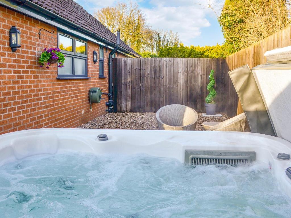 a hot tub in the backyard of a house at California Cottage - Uk42876 in Wilberfoss