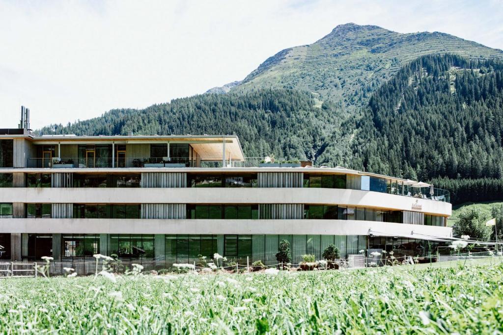 un bâtiment avec une montagne en arrière-plan dans l'établissement Hotel Arlmont 4 Stern Superior, à Sankt Anton am Arlberg