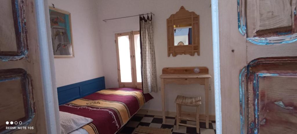 a small bedroom with a bed and a window at Vallparadis Pension Familiar" FIRDAUS" in Chefchaouen