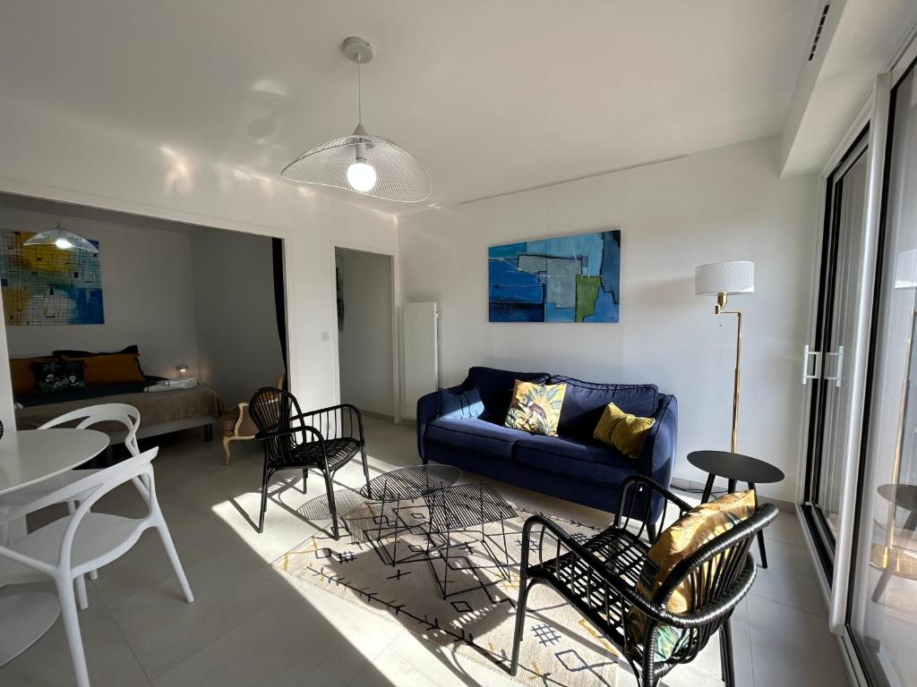 sala de estar con sofá azul y sillas en Corniche - Bénodet, en Bénodet