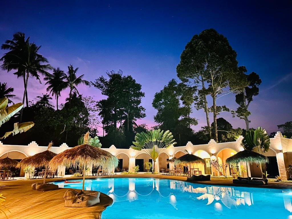 a resort with a large swimming pool at night at Zibá Home Suites in Lamai