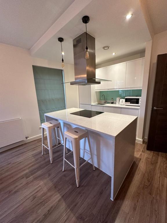 a kitchen with a white counter and stools in it at BigKings Stylish 1Bed Apartment in central Manchester in Manchester