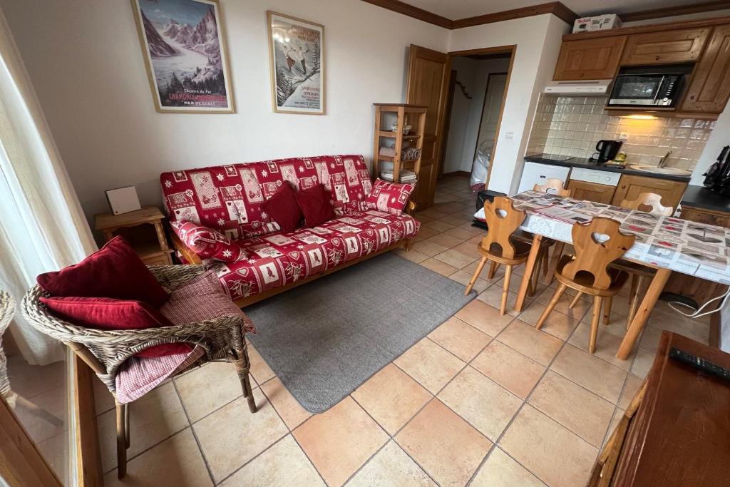 een woonkamer met een rode bank en een tafel bij Chalet de Montalbert 22B in Montalbert