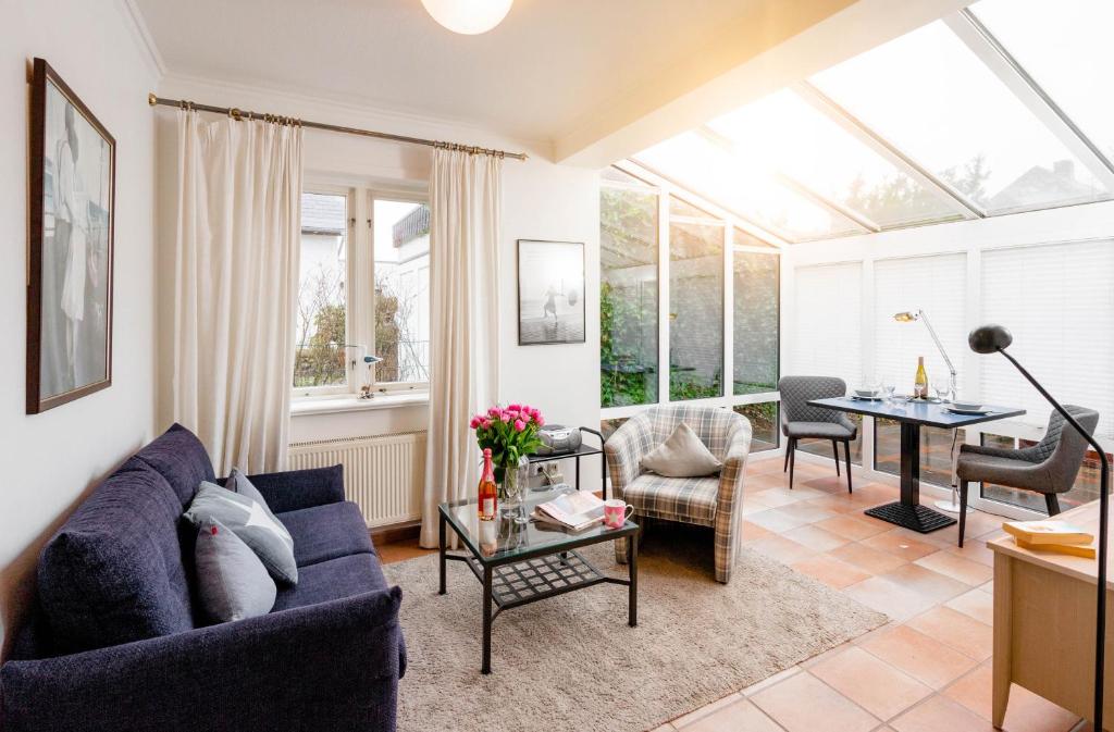 un salon avec un canapé bleu et une table dans l'établissement Ferienwohnung Bootsmann, à Westerland