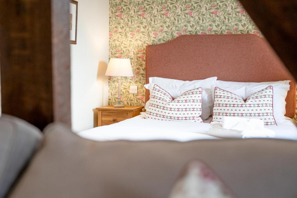 a bedroom with a bed with red and white pillows at The Richard Onslow in Cranleigh