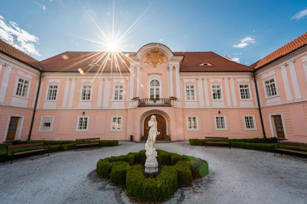 a building with a statue in the middle of a courtyard at Zamek Hradek u Susice in Hrádek