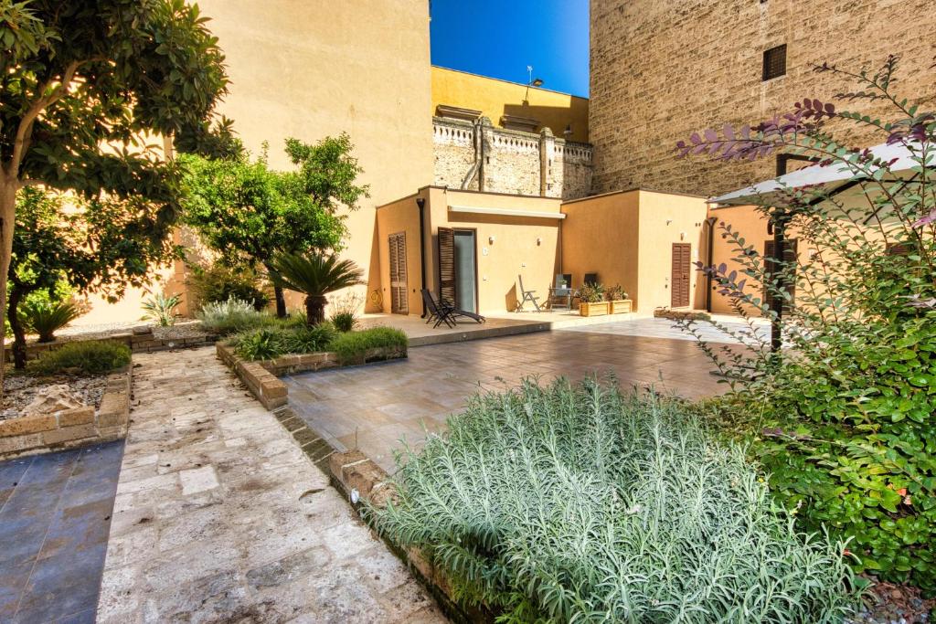 einen Innenhof eines Gebäudes mit Bäumen und Pflanzen in der Unterkunft Giardino dei Lenti - Self check-in Apartments in Bari