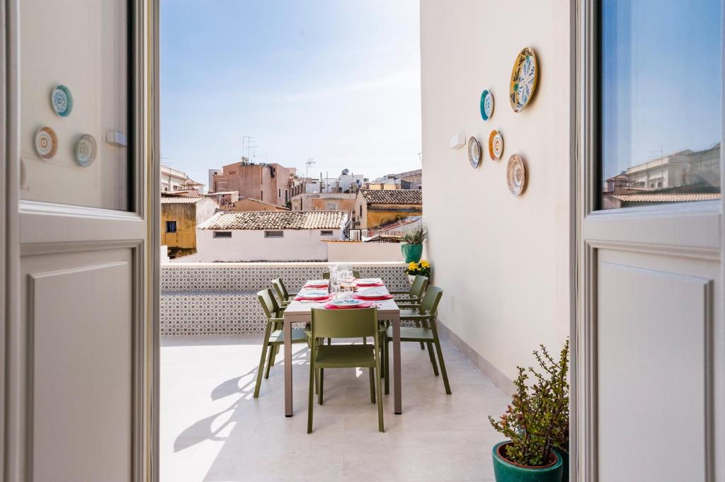 un tavolo e sedie su un balcone con vista di 2 Soru Ortigia Holiday Home - Attico con terrazza a Siracusa