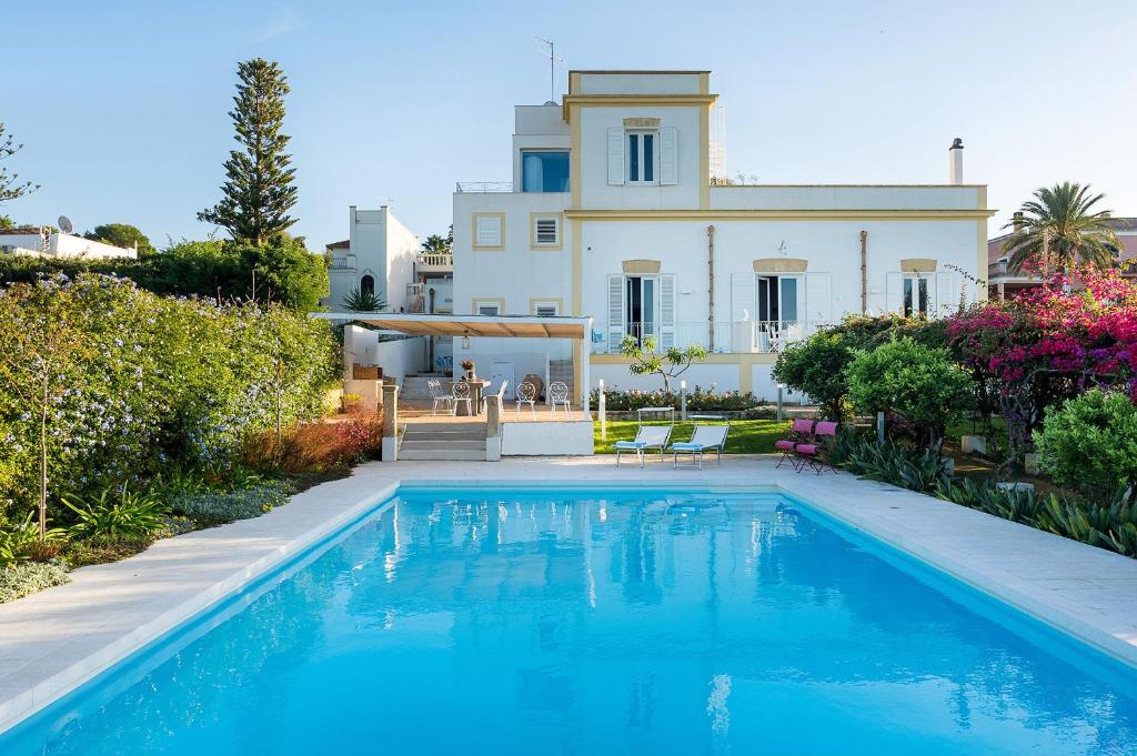a villa with a swimming pool in front of a house at Il Giardino Ritrovato in Marsala