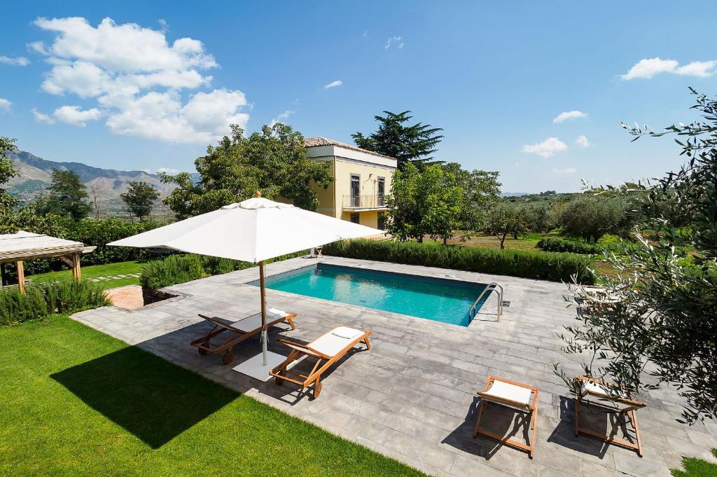 a pool with two chairs and an umbrella at Nerello Mascalese in Montelaguardia