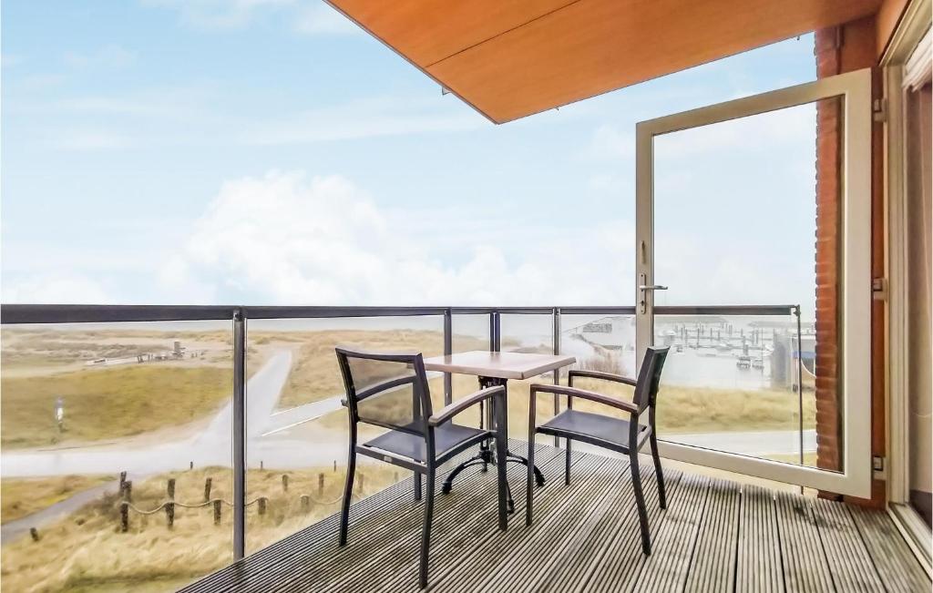 een tafel en 2 stoelen op een balkon met uitzicht bij Beautiful Apartment In Cadzand-bad With Wifi in Cadzand-Bad