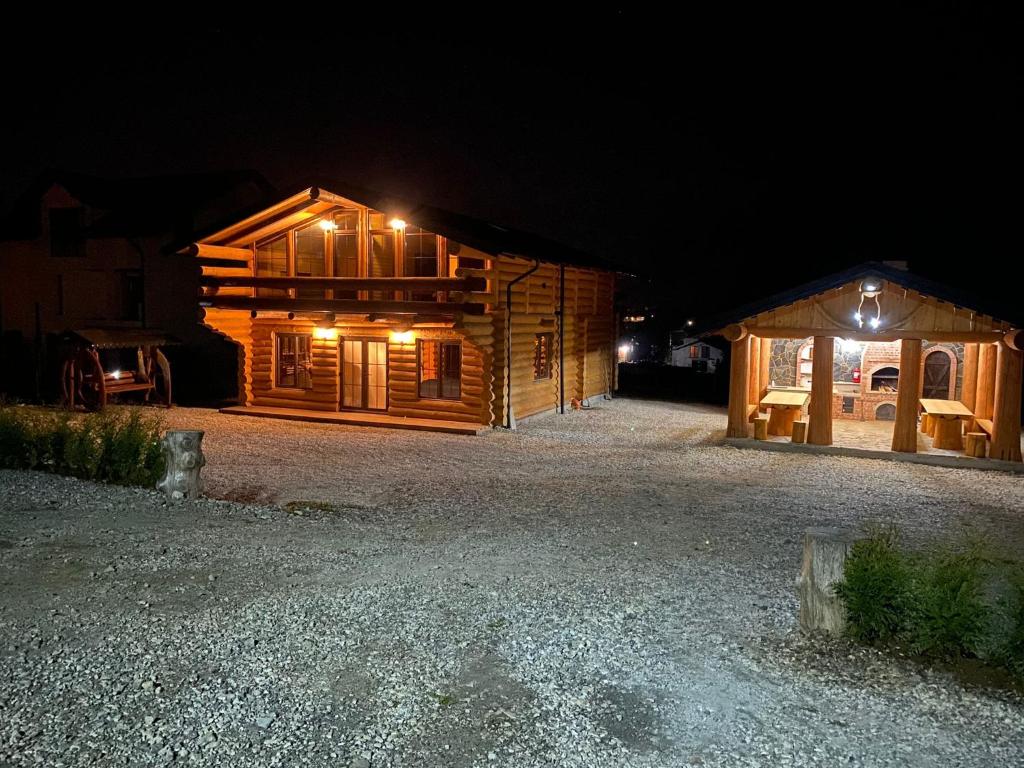 een hut 's nachts met de lichten aan bij Chalet Poligon in Vatra Dornei