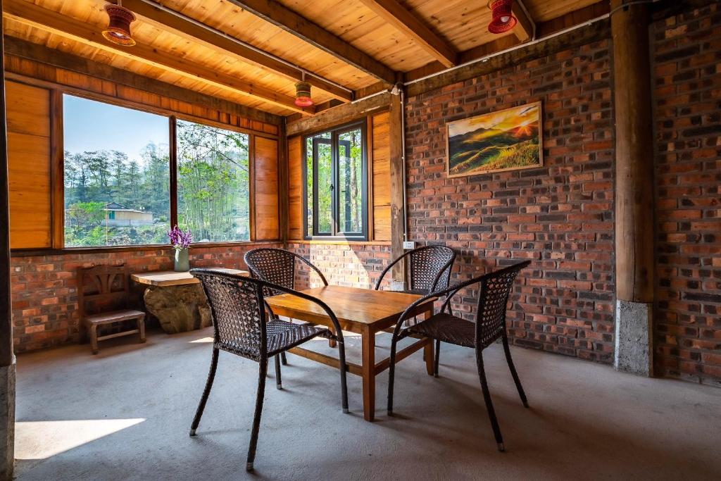 una mesa y sillas en una habitación con una pared de ladrillo en River mountain view homestay en Sa Pa