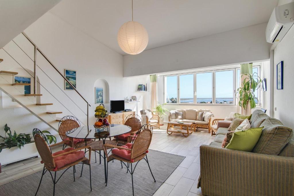 een woonkamer met een bank en een tafel en stoelen bij Casa de Mar in Moncarapacho