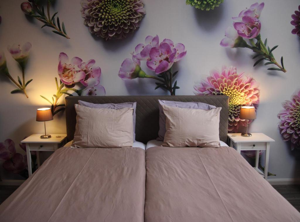 1 dormitorio con 1 cama con flores en la pared en Sint-Anthonijshoek, en Koudekerke
