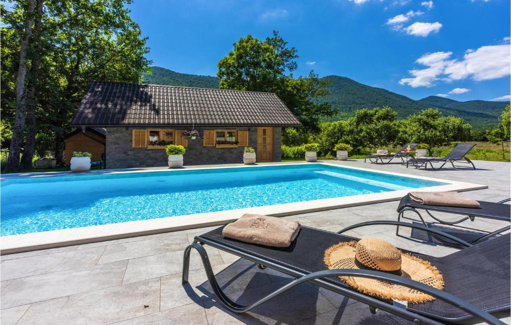 a swimming pool with chairs and a house at Cozy Home In Buzim With Sauna in Bužim
