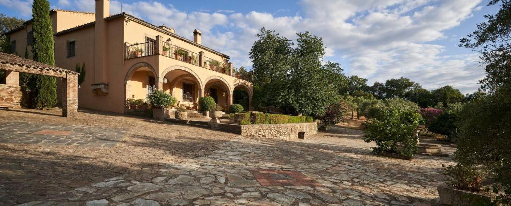 una casa grande con una carretera de piedra delante de ella en Lagar La Pizarra Casa Rural en Trujillo