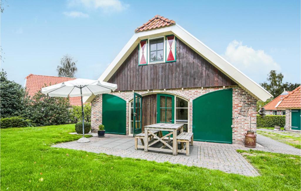 une maison avec une table de pique-nique et un parasol dans l'établissement Amazing Home In Ijhorst With Wifi, à IJhorst