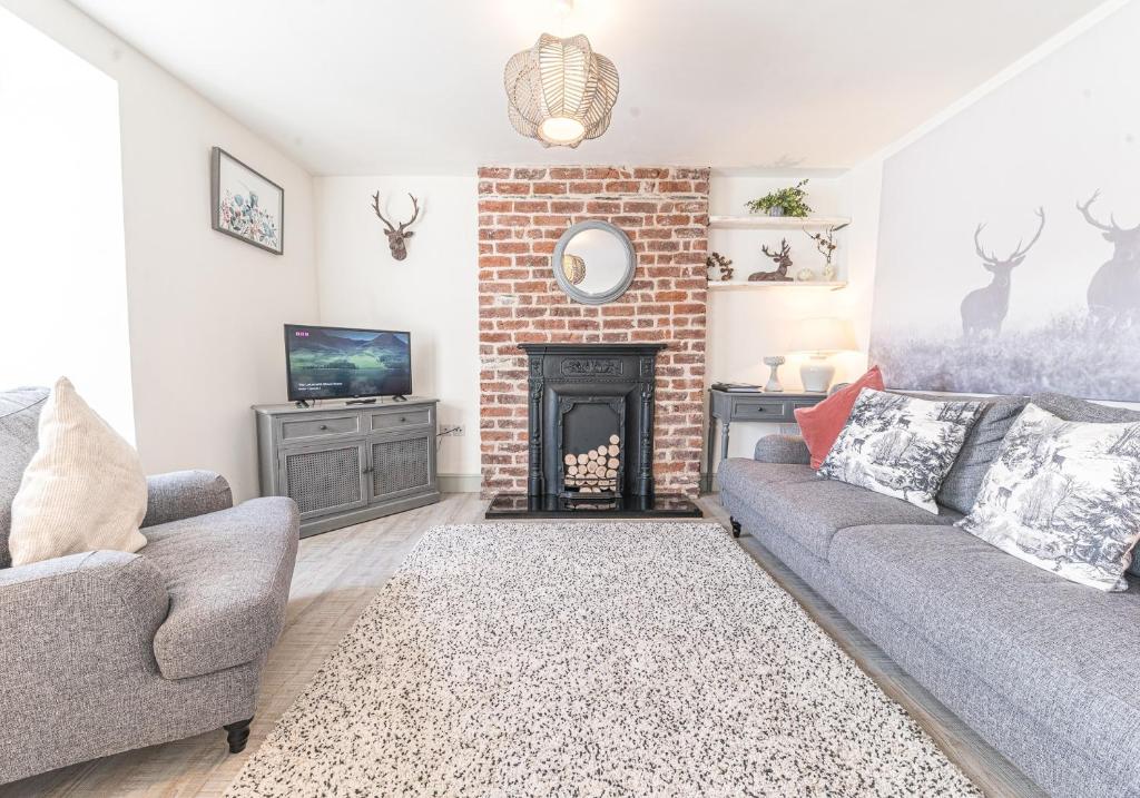 ein Wohnzimmer mit einem Sofa und einem Kamin in der Unterkunft Victoria Apartment, Derwent House in Keswick