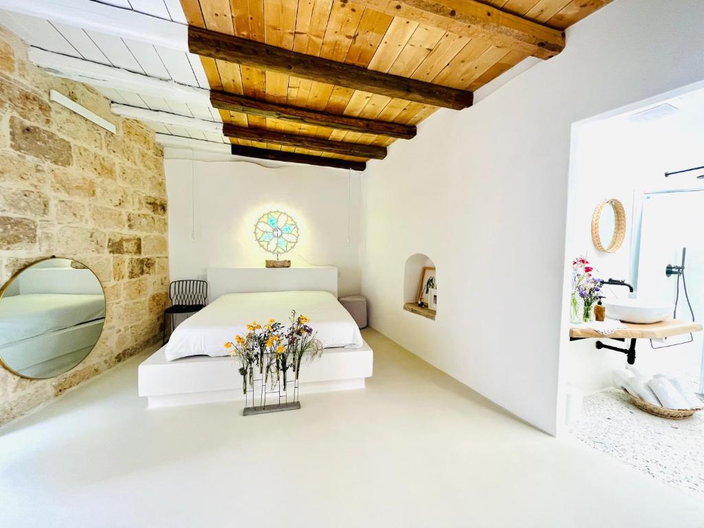 a bedroom with a bed and a stone wall at Hydria guest house art gallery in Acquaviva delle Fonti