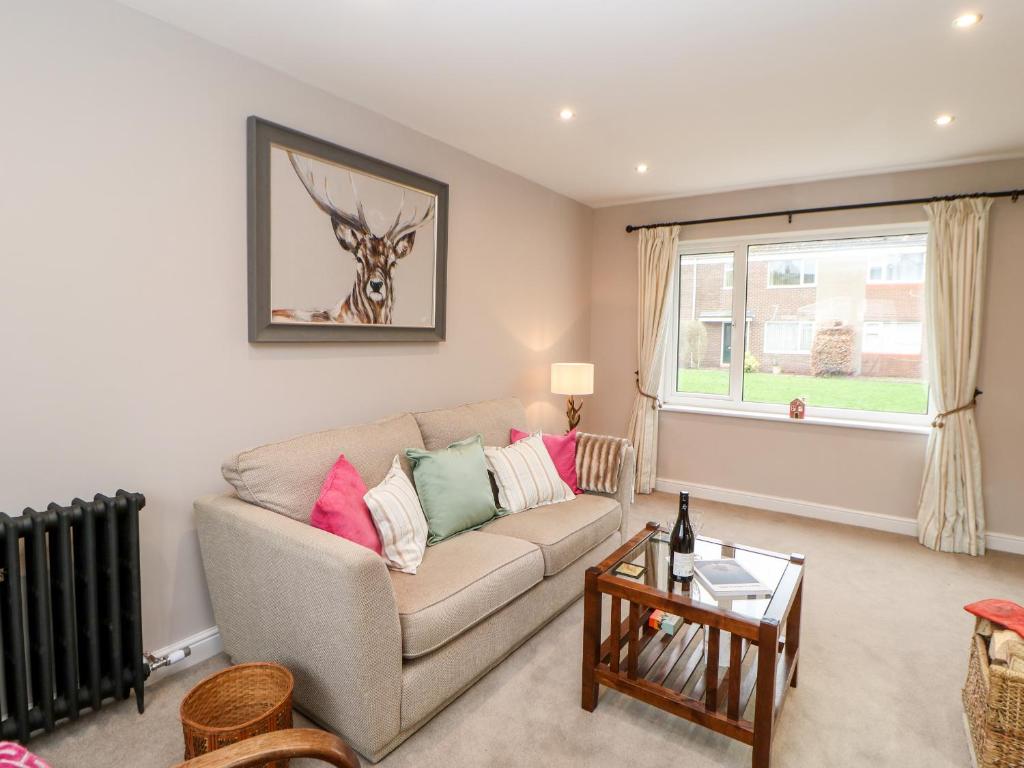 uma sala de estar com um sofá e uma janela em Willows em Corbridge