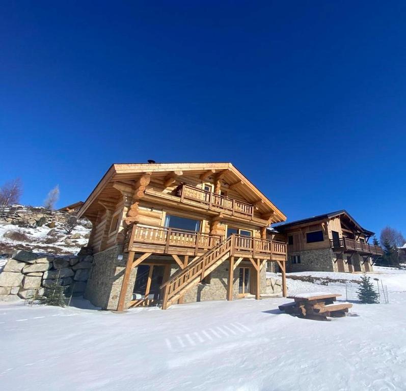 a log cabin in the snow with a bench in front at Chalet de 6 chambres avec sauna terrasse amenagee et wifi a Font Romeu Odeillo Via a 1 km des pistes in Font-Romeu-Odeillo-Via