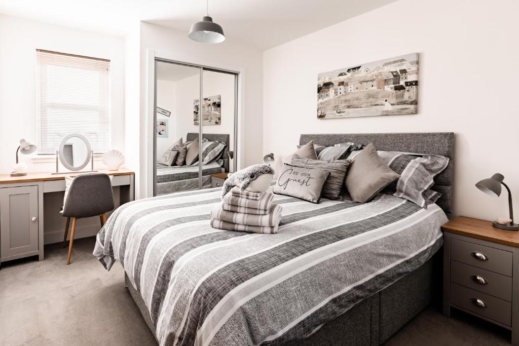 a bedroom with a large bed with a desk and a mirror at Jules By The Sea Anstruther in Anstruther