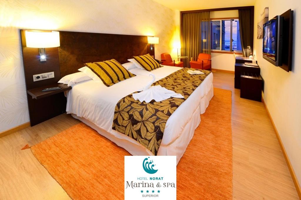 a hotel room with a large bed with a sign on it at Hotel Norat Marina & Spa 4* Superior in O Grove