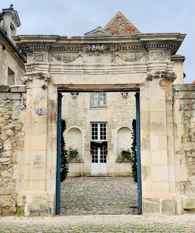 an entrance to an old stone building with a door at La Maison Saint Joseph in Crépy-en-Valois