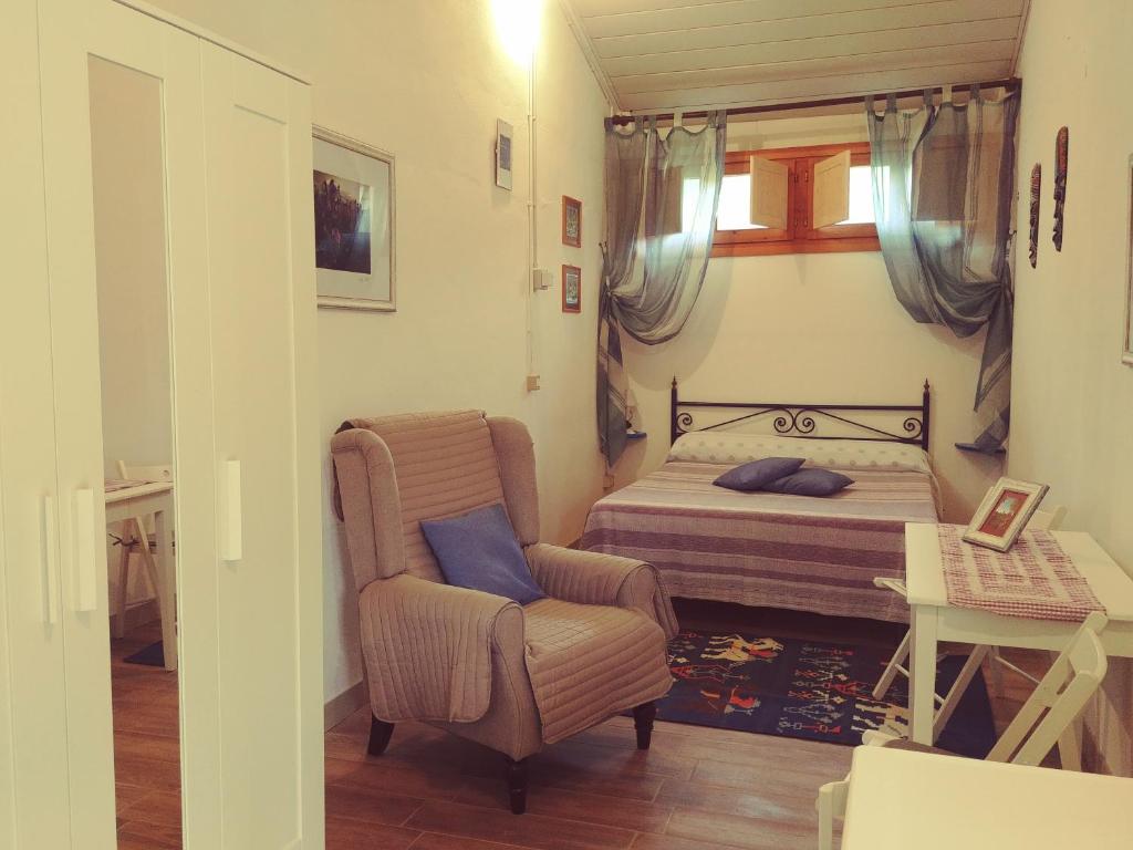 1 dormitorio con 1 cama y 1 silla en Agriturismo Botro en Pulicciano