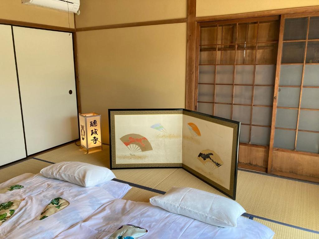 due letti in una stanza con quadri sul pavimento di 宿坊 れんじょう寺 奈良 Temple Stay Renjoji Nara a Nara