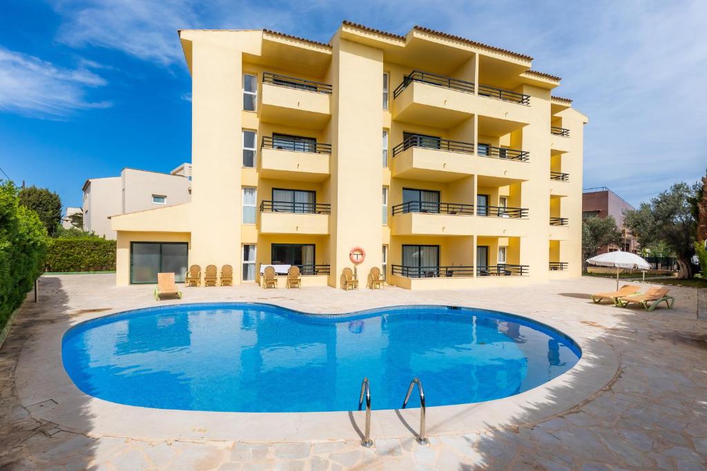 un bâtiment avec une piscine en face d'un bâtiment dans l'établissement Apto con Terraza 202, à Cala Millor