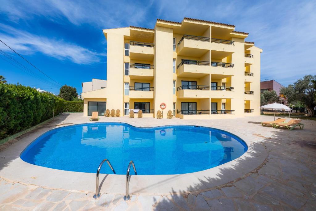 budynek z dużym basenem przed budynkiem w obiekcie Apto con Terraza 103 w Cala Millor