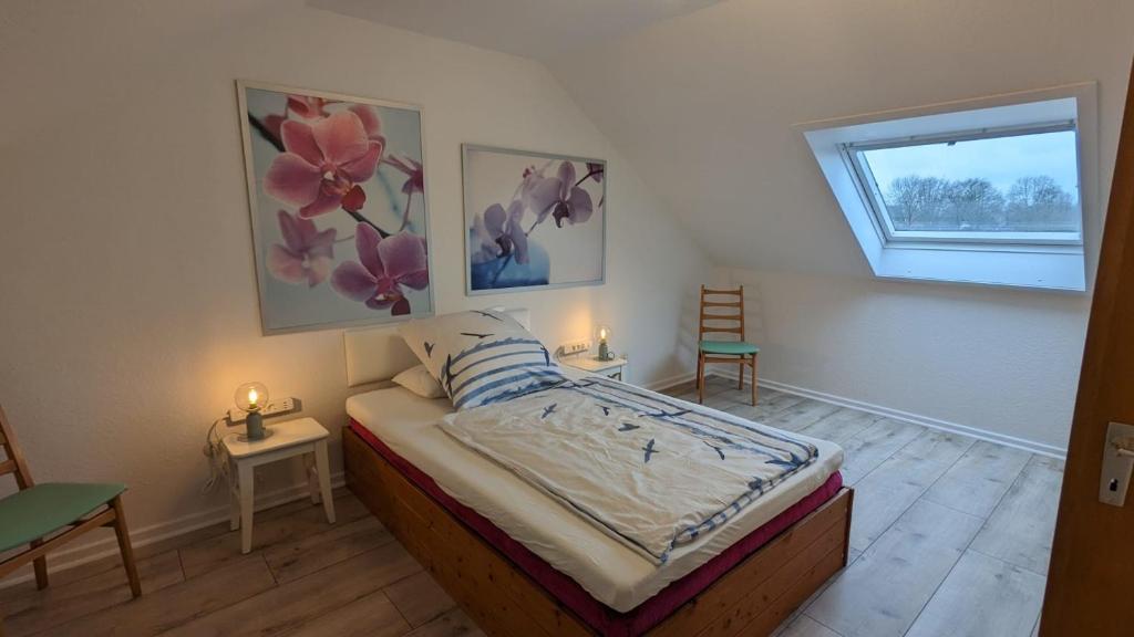 a bedroom with a bed with two pictures on the wall at "Haus zwischen Nord- und Ostsee" in Büdelsdorf
