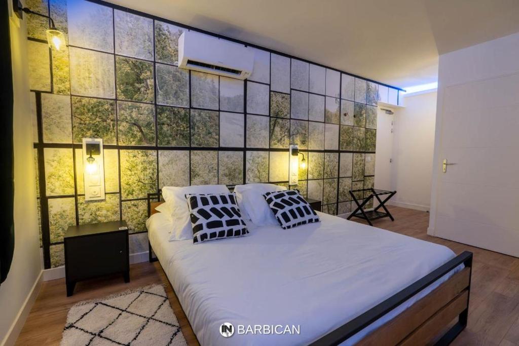 a bedroom with a large bed and a wall of tiles at Barbican in Villars-les-Dombes