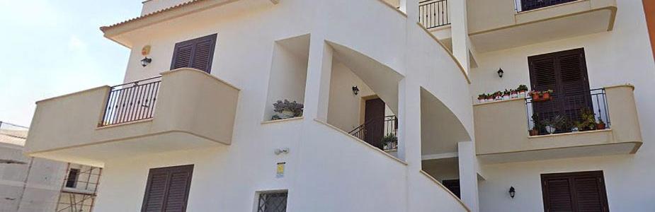 a white building with balconies and plants on it at Rosa's House Bed and Breakfast in Santa Margherita di Belice