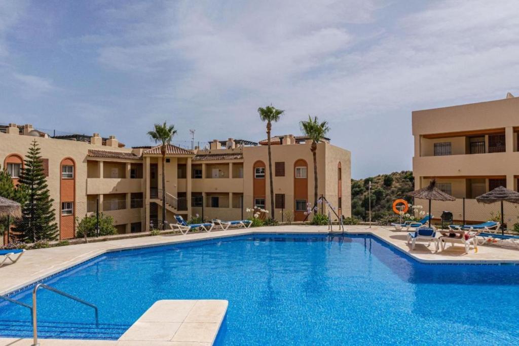 una gran piscina frente a algunos edificios en Nice apartment in Riviera del Sol Calahonda, en Málaga