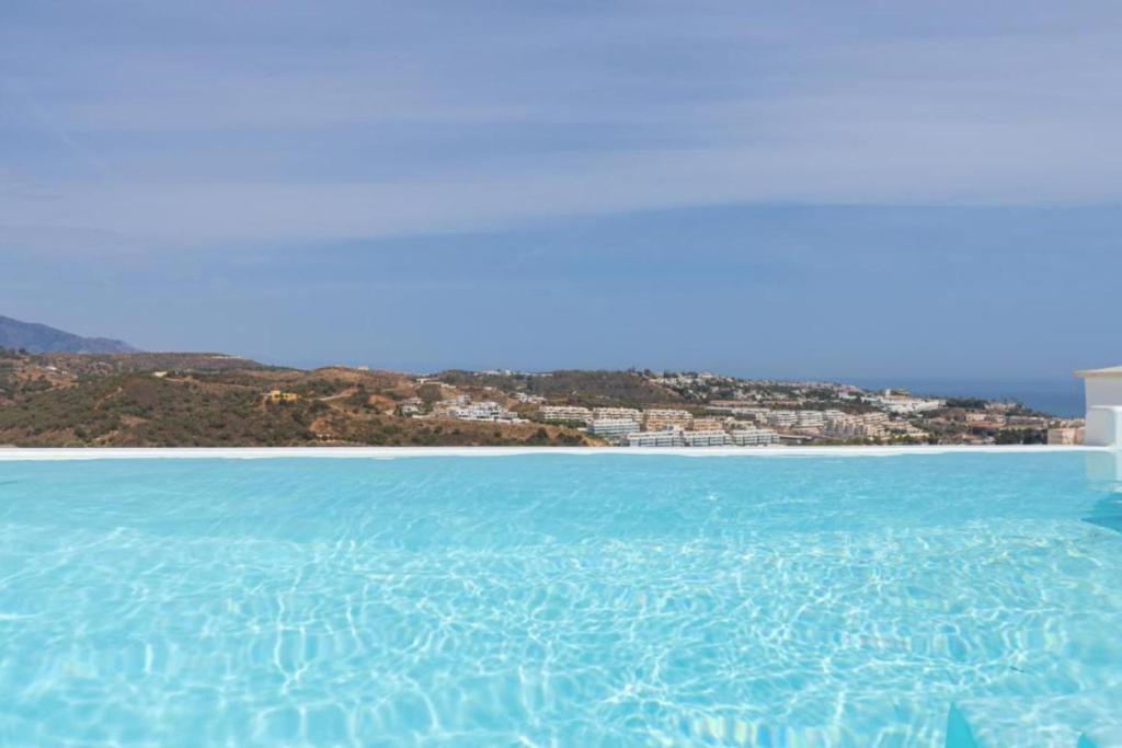 duży zbiornik wody z miastem w tle w obiekcie Luxurious penthouse in La Cala Casa Banderas - 3 Golf Facilites close by! w mieście La Cala de Mijas