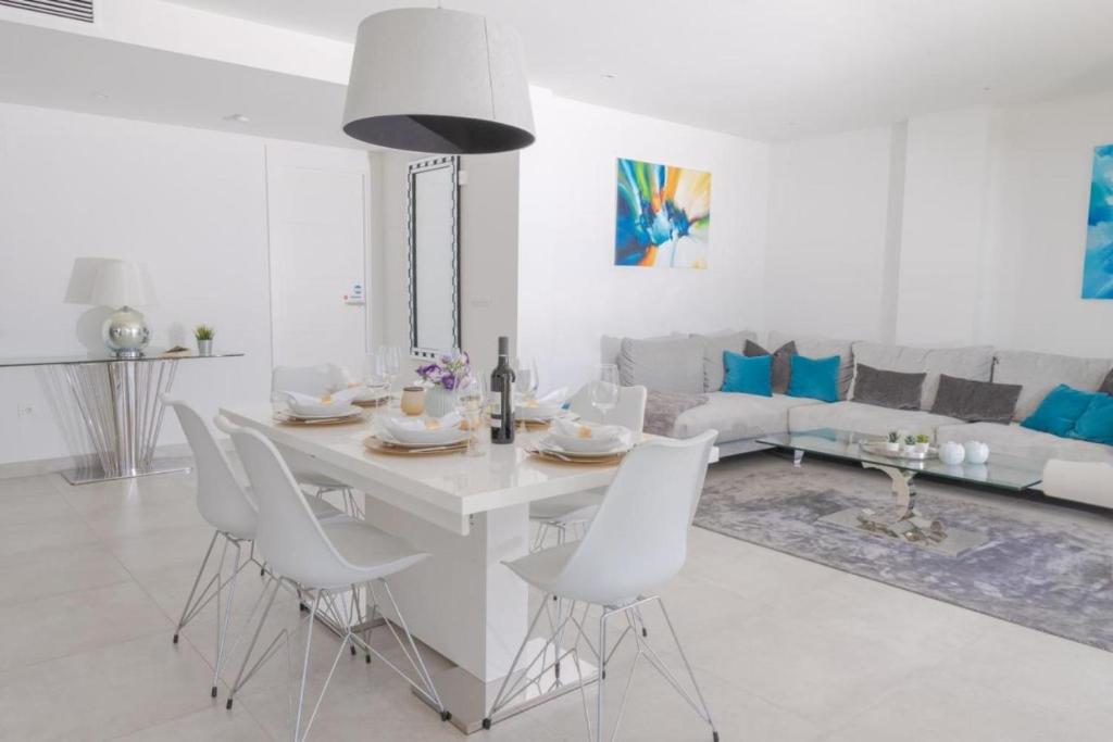 Biały salon z białym stołem i krzesłami w obiekcie Luxurious penthouse in La Cala Casa Banderas - 3 Golf Facilites close by! w mieście La Cala de Mijas