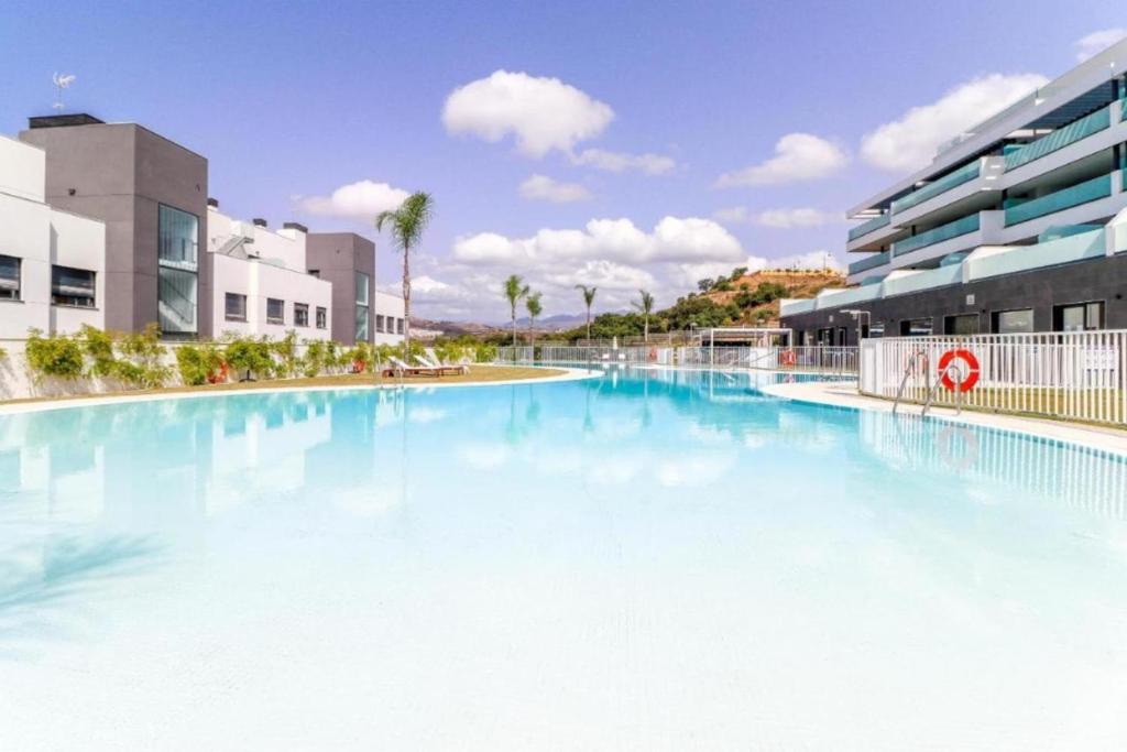 uma grande piscina com água azul em frente aos edifícios em Amazing 3 bedroom apartment Cala Serena La Cala de Mijas em La Cala de Mijas